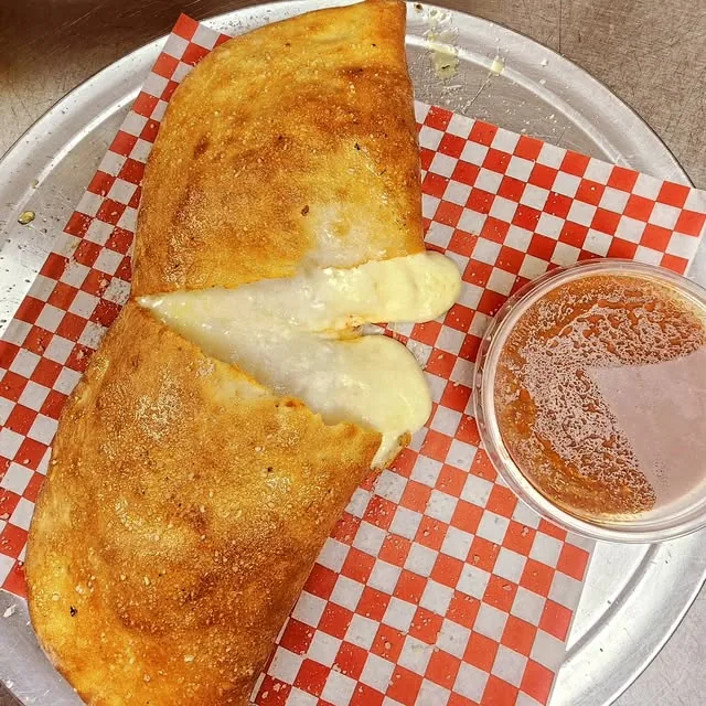 A golden calzone filled with melted cheese
